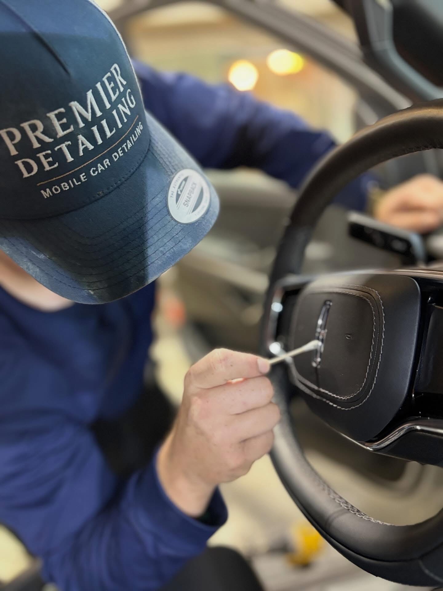 Joe Young Premier Detailing LLC owner detail work on steering wheel — mobile car detailing Johnson County Kansas