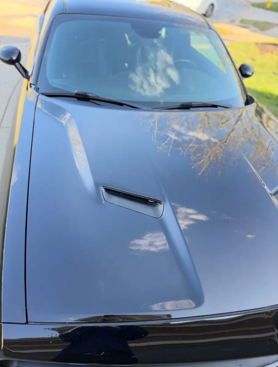 Dodge Challenger exterior after mobile wash, glossy black hood and windshield reflecting trees,Premier Detailing LLC De Soto Olathe Kansas